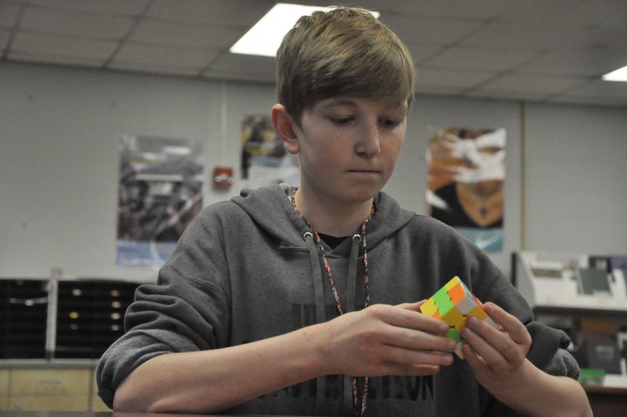 Tim Reed contemplates his favorite puzzle. I think [the Rubiks Cube] is nerdy, but I also think its cool. I just enjoy doing it, Reed says. 
