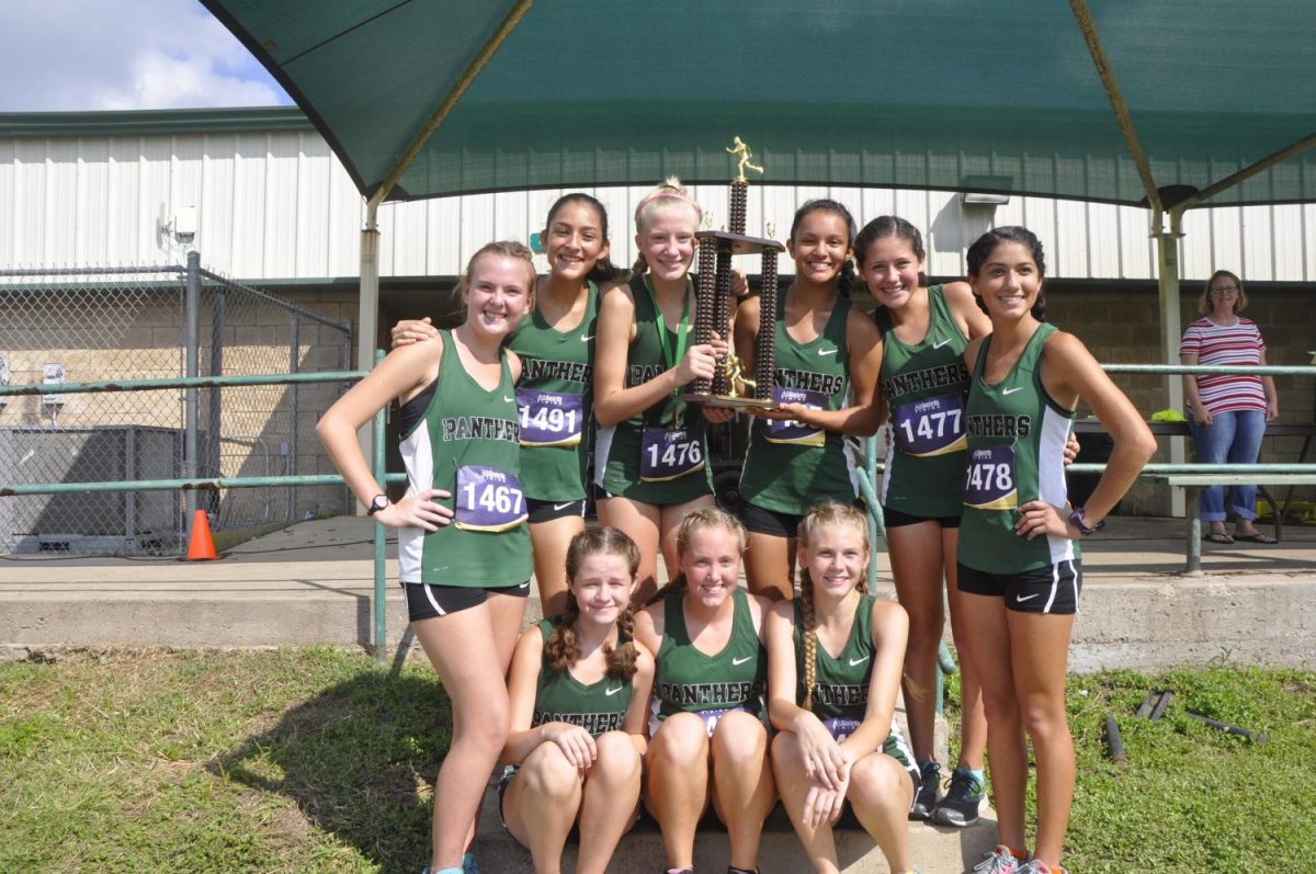 The JV team hold up their second place trophy after the Brenham Hillacious meet on Sept. 23.