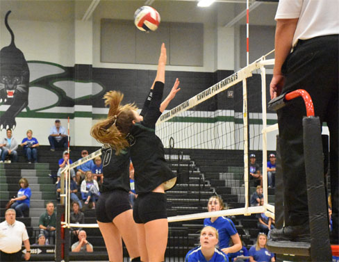 Varsity volleyball players senior Alex Plummer and junior Andie Unwin attempt to block a ball coming over the net in the Sept. 26 game against Barbers Hill.