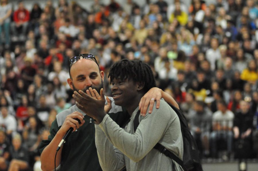 Offensive coordinator Bruce Cox introduces senior Tylan Johnson at the first pep rally as they encourage fans to show up for the football games this season.