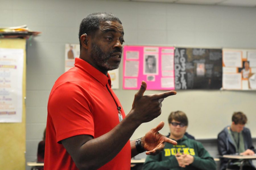 American Sign Language teacher Darnell Woods communicates with students in his fifth period class on March 22. Woods’ mom first noticed he was hard of hearing when he was 5 years old. He has worn hearing aids since third grade, but his hearing has progressively worsened over time.