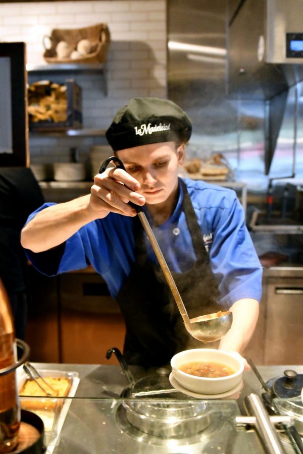 Senior Marcus Block prepares soup for customers while working at la Madeleine on Oct. 26. Block has held a number of different jobs and works about 18 hours per week at la Madeleine.