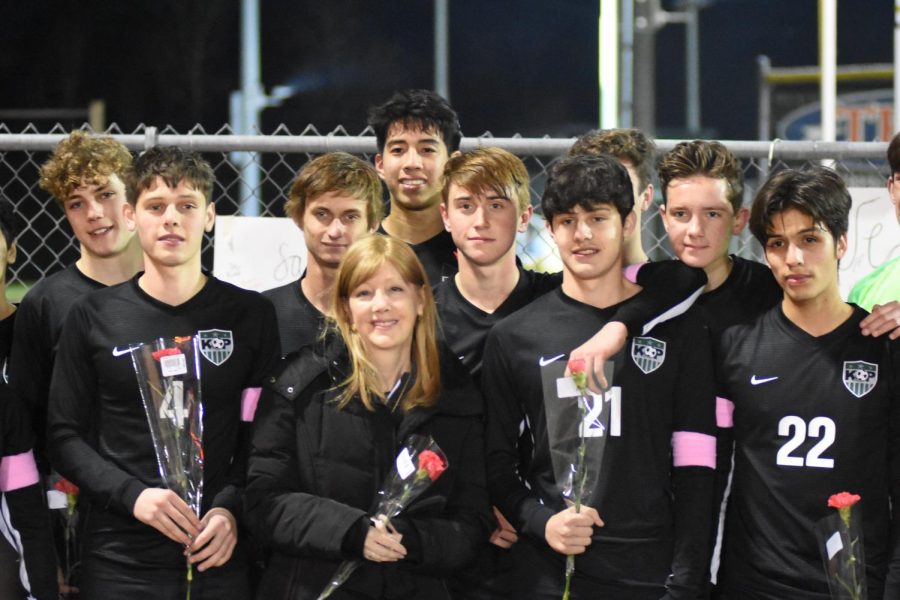 Kristi Selva stands next to her sons Cristian Selva, 10, and Armando Selva, 12, during halftime of the Feb. 14 boys soccer game. The team honored Selva, who is going through cancer treatments this spring.
