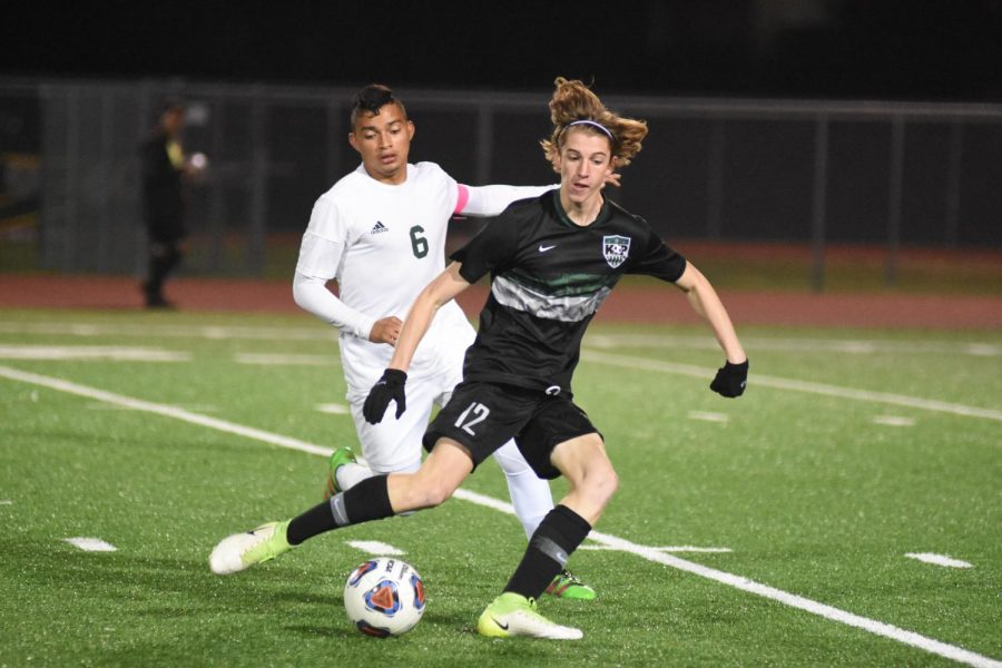 Senior Jacob Bruce dribbles away from a Sharpstown player earlier this year. The Panthers were eliminated by Sharpstown one game away from State last year but avenged that loss this season. The boys were undefeated and dominated the district prior to the season being suspended. 
