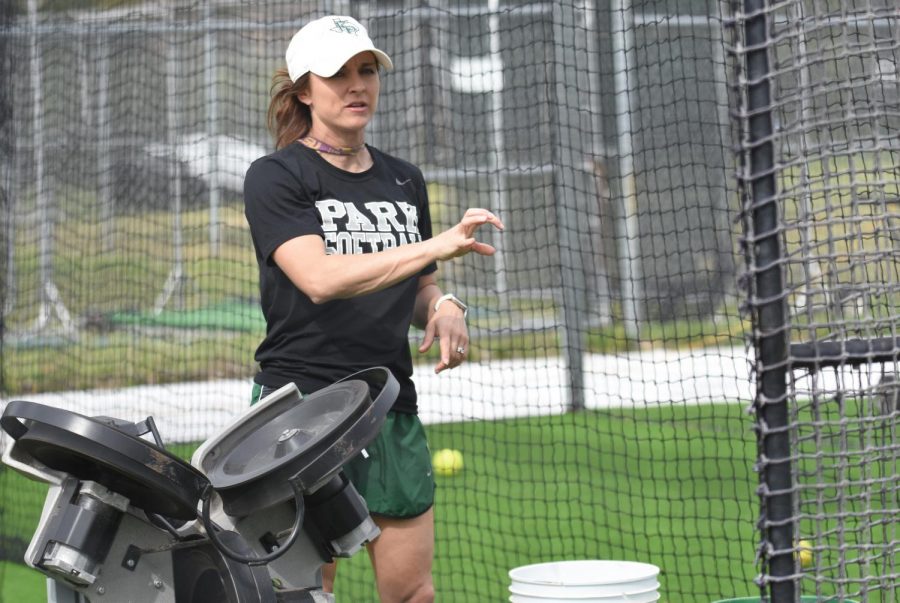 Softball coach Sara Koym works during practice with her varsity softball players. The team had only two home games before the season was canceled for the year.