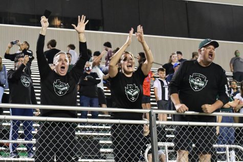 Parents cheer at the railing as they celebrate the boys soccer team's 5-4 victory over Pharr Valley View in the state semifinals. Despite games being so far away, the families and Kingwood Park community have traveled to watch the team play.