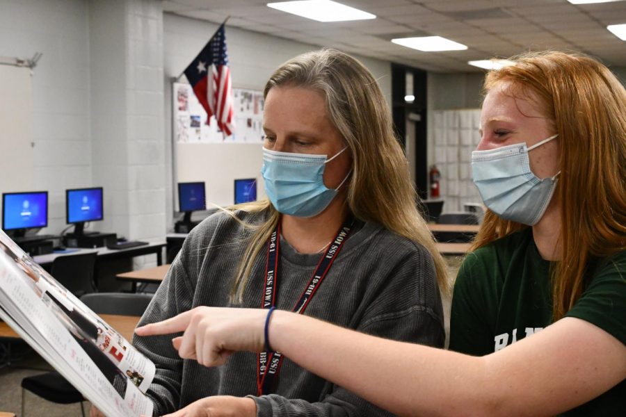 Journalism teacher Megan Ortiz looks over a yearbook spread with freshman Arleigh Doehring. 