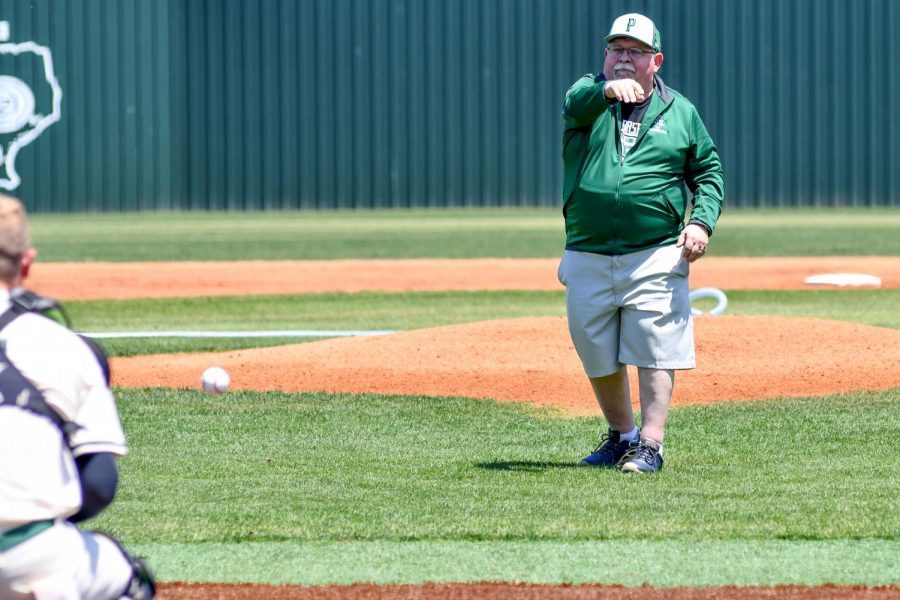 Joe Ehrhardt throws out the first pitch at the varsity baseball game against Dayton on April 24. Ehrhardt teaches Principles of Physics and Astronomy. He has always been a major supporter of the baseball team. 