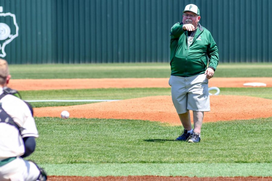 Joe+Ehrhardt+throws+out+the+first+pitch+at+the+varsity+baseball+game+against+Dayton+on+April+24.+Ehrhardt+teaches+Principles+of+Physics+and+Astronomy.+He+has+always+been+a+major+supporter+of+the+baseball+team.+