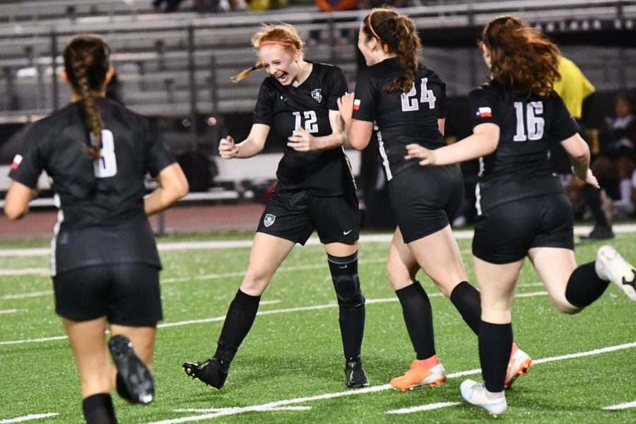 Emma Yeager pumps her first as her teammates rush to congratulate her after scoring her third goal against Porter on March 12. Her final goal of the game was her 41st of the year and put her atop the record books for goals in a season at Kingwood Park.