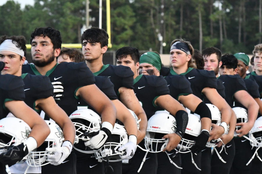 The senior football team lines up for the national anthem before their game against South Houston.