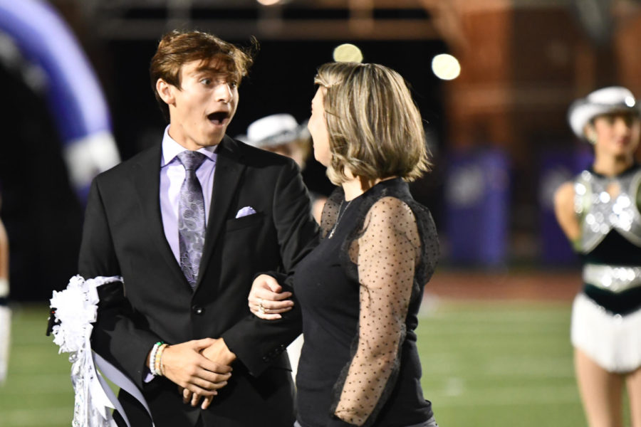 Senior Kade Terrell looks at his mom in shock as he hears his name announced as the homecoming king during halftime of the football game on Oct. 15.