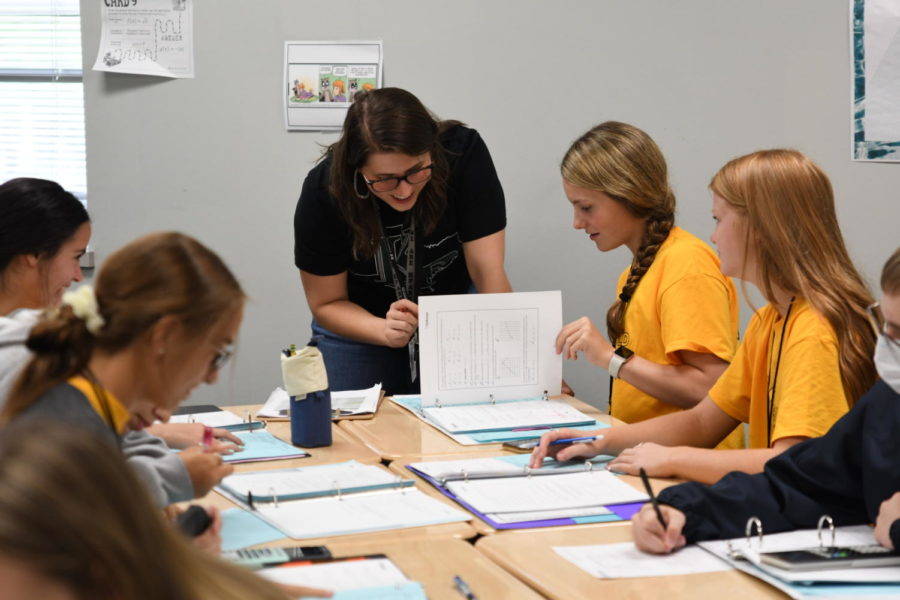 Math teacher Caroline Wick does a notebook check with junior Carlie Solomon during Algebra II in September. 