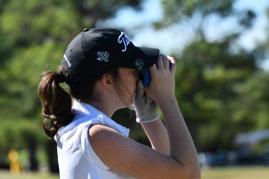While on the range at Gleannloch Pines, Kendall Kerr uses her rangefinder to see how far away the red flag is. A rangefinder is very useful to mark distances such as greens, markers, ditches, and other obstacles.
