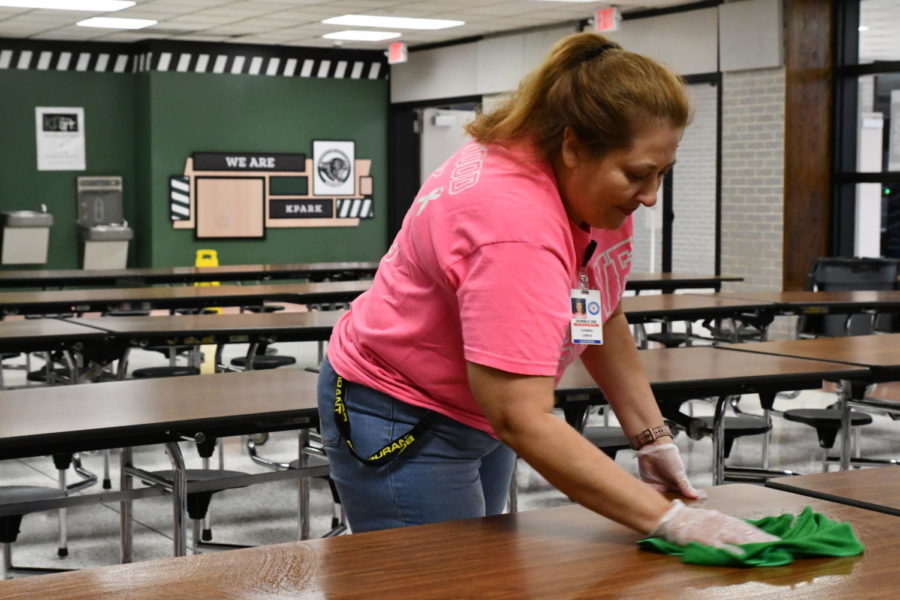Head custodian Carmen Lemus wipes down all the of the cafeteria tables as lunch ends. She has worked at Kingwood Park for 11 years and in charge of the custodial staff for the past three.