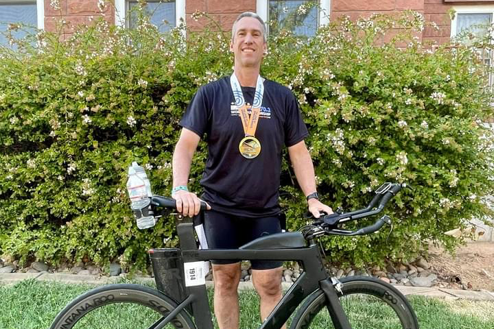 Greg McLain stands with his bike after the Iron Man 70.3 World Championship. 