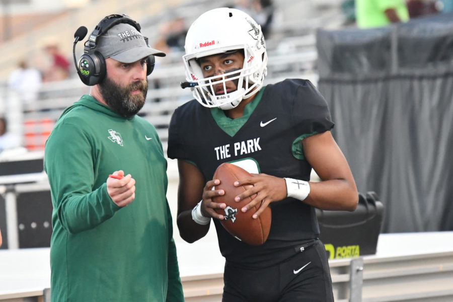 Offensive coordinator Bruce Cox speaks with sophomore quarterback Jaxon Sims prior to a game at Turner Stadium on Sept. 23.  