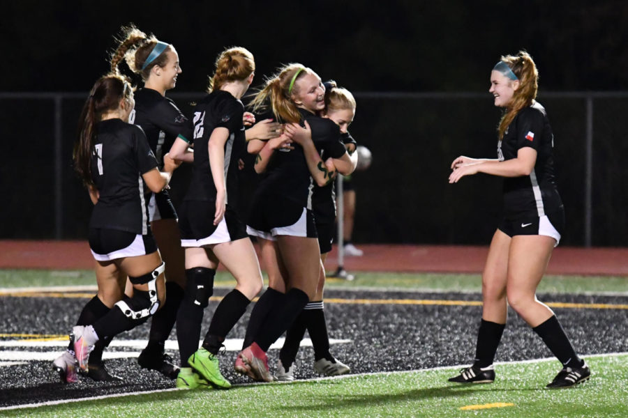 Junior Brynn Baldon hugs junior Nadia Lawrence as sophomore Addie Gray joins the goal celebration. Baldon headed in a corner kick by senior Kathleen Ortiz to give the Panthers an early 1-0 lead on March 4.
