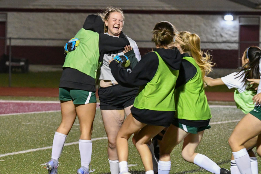 Players+race+to+celebrate+with+freshman+Courtney+Daniel%2C+who+was+in+goal+during+the+penalty+shootout+on+March+24+against+College+Station.+