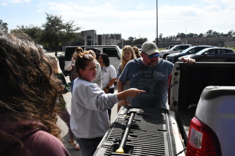 Forensics teacher Tanya Johnston works with students in her class to help transport the dead hog from the pickup truck to the woods near the parking lot, where they will watch it decompose over the next few months.