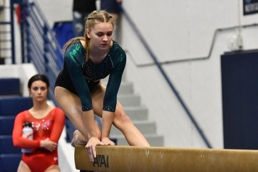 Sophomore Sydney Gilstrap begins her balance beam routine in a meet in February. She will compete in every event at the state meet on April 20. 