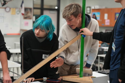 Senior Noah Parker and Junior Grace Cardenas check to see if their target is aligned with their ramp.