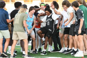 Senior Tyrique Riley shows off his dance moves during the homecoming pep rally with the football team surrounding him. 