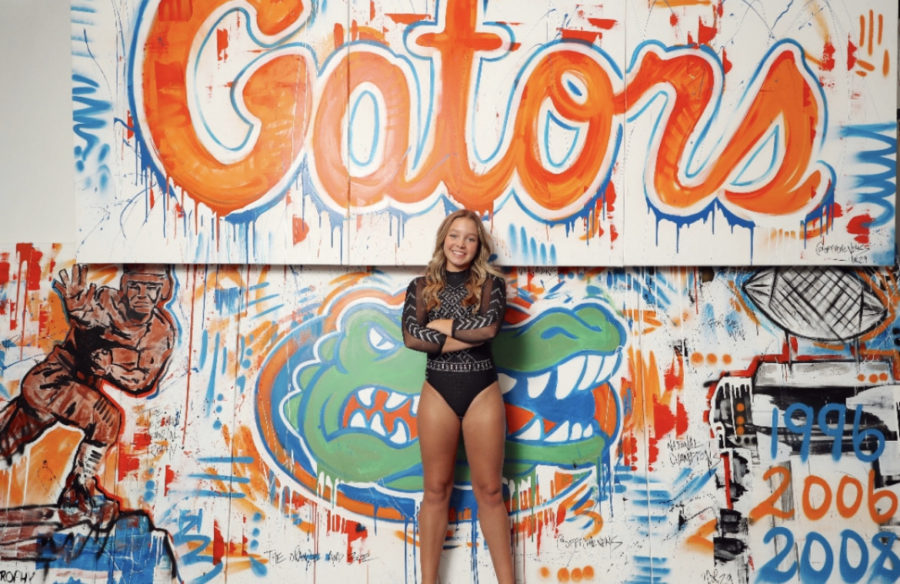 Junior Lily Bruce poses with a University of Florida mural during an official visit to the campus. She verbally committed to the gymnastics program there in the fall. 