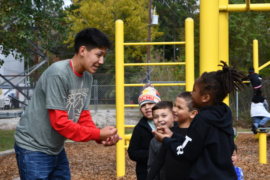 Freshman+Eduardo+Hernandez+plays+rock-paper-scissors+with+students+during+recess+at+Jack+Field+Elementary+during+Day+of+Service.