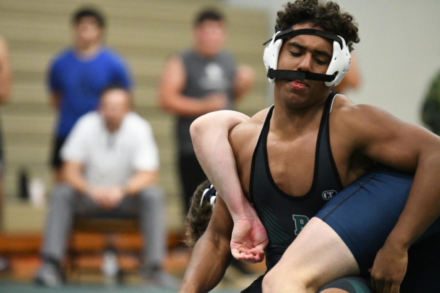 Talon Benton, 10, tries to flip his Kingwood opponent onto the mat as his headgear slips into his face. 