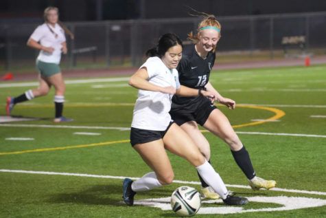 Senior Emma Yeager has fun going against former teammate Lori Do in the second half of the alumni soccer game. 