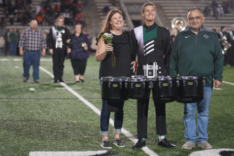 Senior Josh Chavez walks down the football field with his parents during the band’s senior night on Nov. 4.