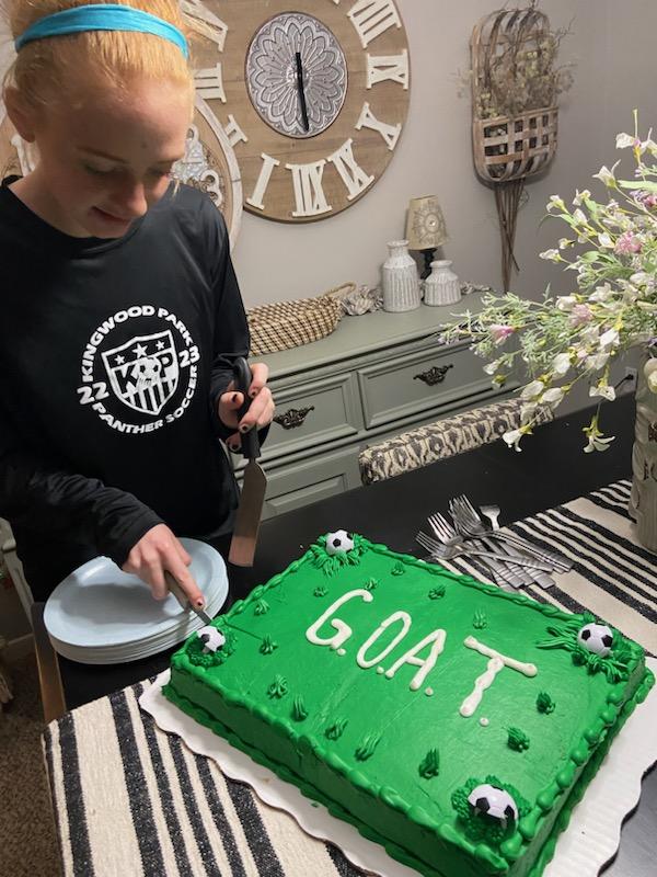 Senior Emma Yeager cuts the chocolate cake her mom pre-ordered her at Walmart on Feb. 14. Yeager broke the all-time scoring record for the girls soccer team with her 107th goal in the first half of Tuesdays game.