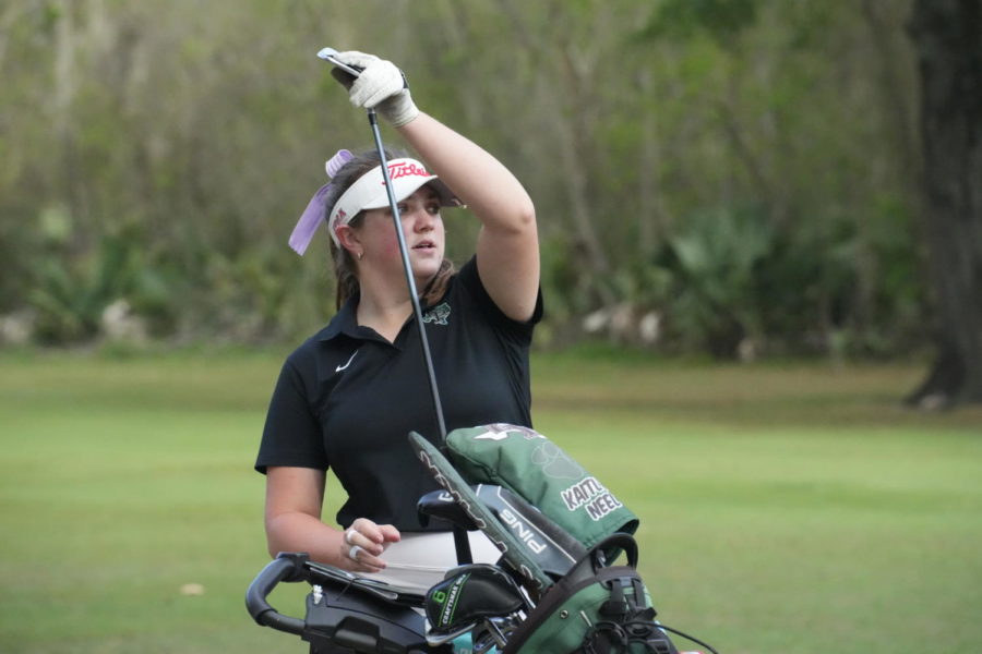 Senior Kaitlyn Neel selects her club during a tournament in March at Kingwood Country Club.