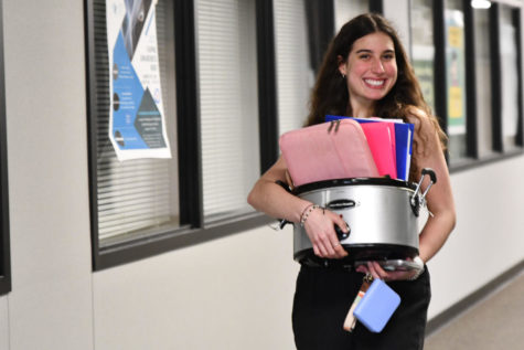 Senior Victoria Goncalo carries her schoolwork in a crock pot on Monday. The seniors have a different theme each day leading up to prom on Saturday. The theme on Monday was anything but a backpack. 