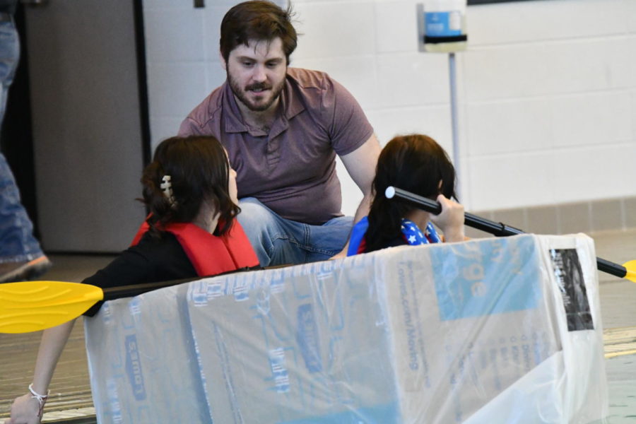 Principles of physics teacher Jacob Butcher helps his students during boat races in April. 