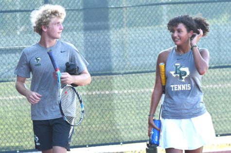 Sophomores Andrew Carson and Olivia Licona walk together after playing a varsity mixed doubles match in the fall. Both competed in JV tournaments in the spring. 