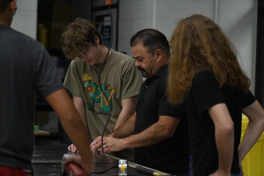 Auto collision teacher Jeff Wilson works with students in class during a project.