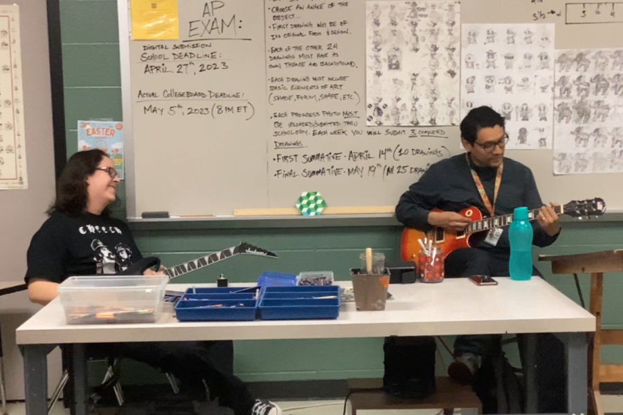 Junior Seth Limon and art teacher Miguel Alvarez play guitar with each other.