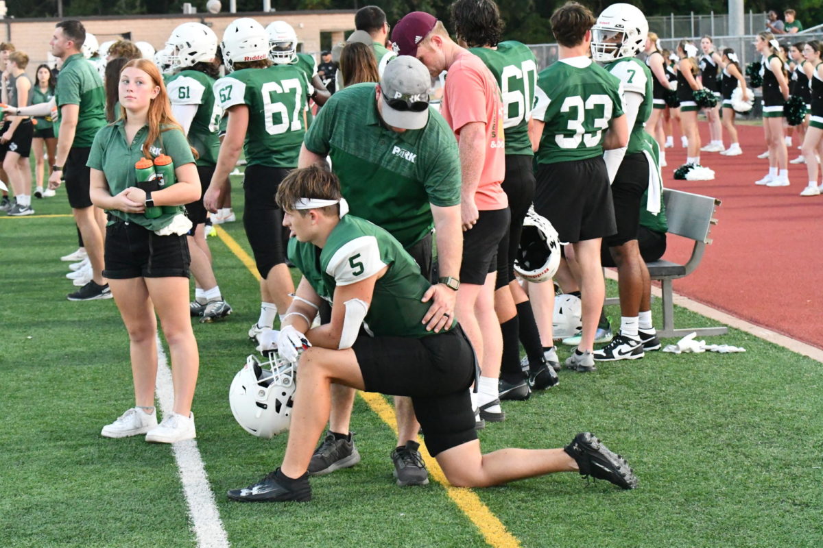 Head athletic trainer Daniel Scalia works with senior Luke Kerscher on the sidelines during the Galena Park scrimmage.