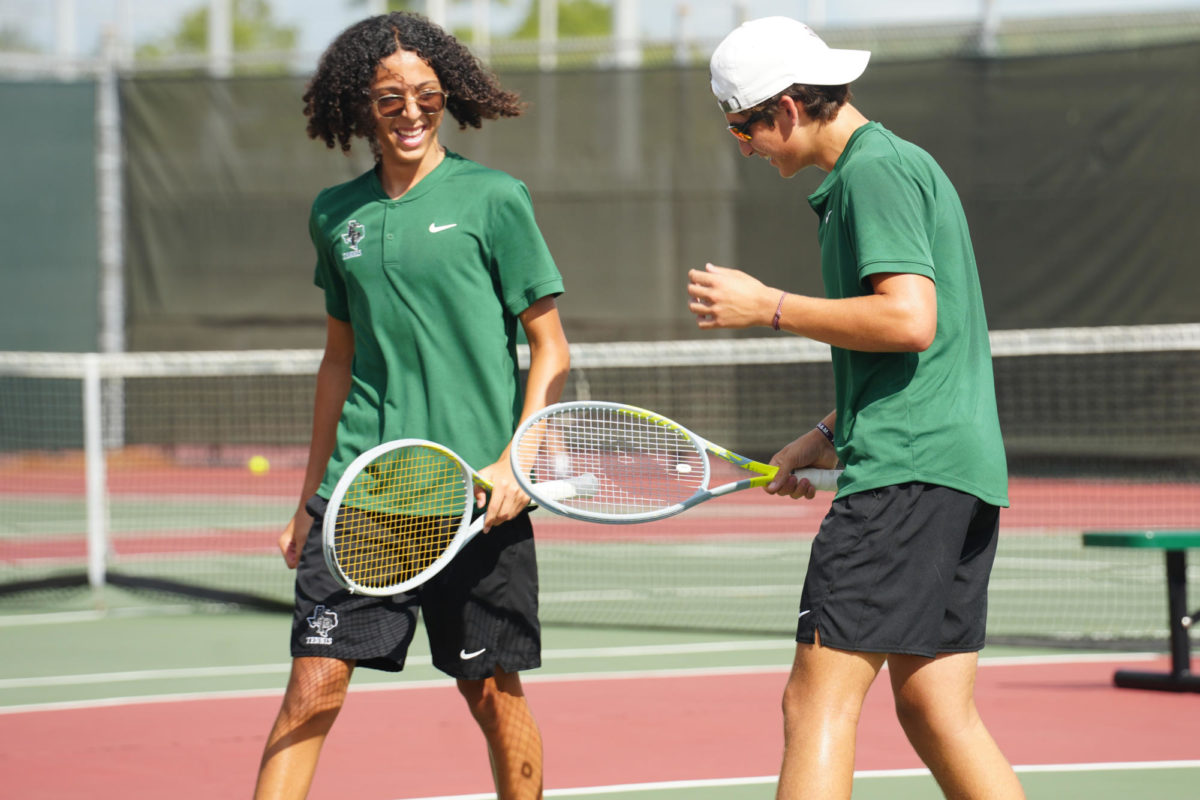 Juniors Santiago Salazar and Ben Smoot talk after earning a point in a doubles match against Clear Brook.