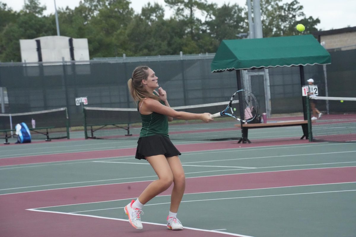 Junior Brook OBrien swings her tennis racquet at the ball.