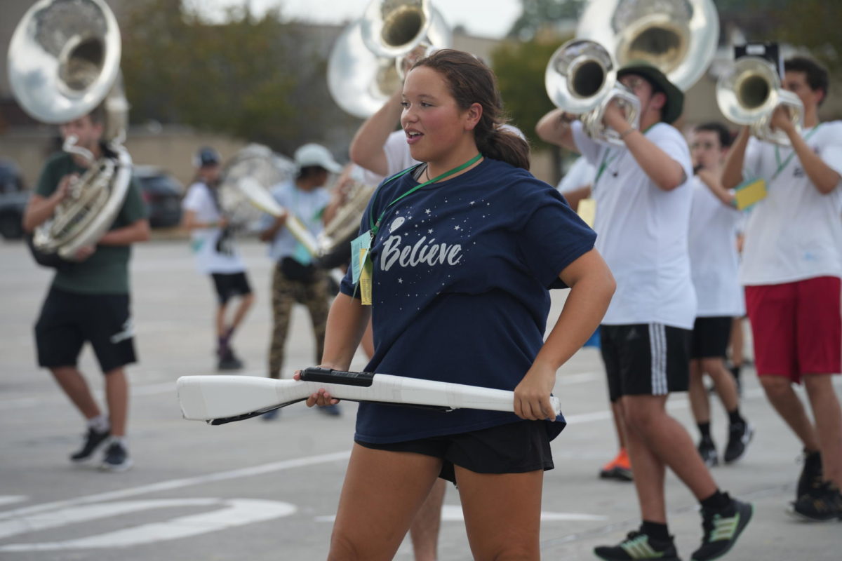 Junior Andrea Palmer practices with the band on the school parking lot. She spent much of her summer with the Seattle Cascades, where she traveled and performed with the groups color guard.
