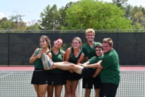 Tennis team members Julianne Chamberlain, Lilli Flores, Brooke OBrien, Andrew Carson, Hugo Houel, and Robert Geiger all pose together on the court.