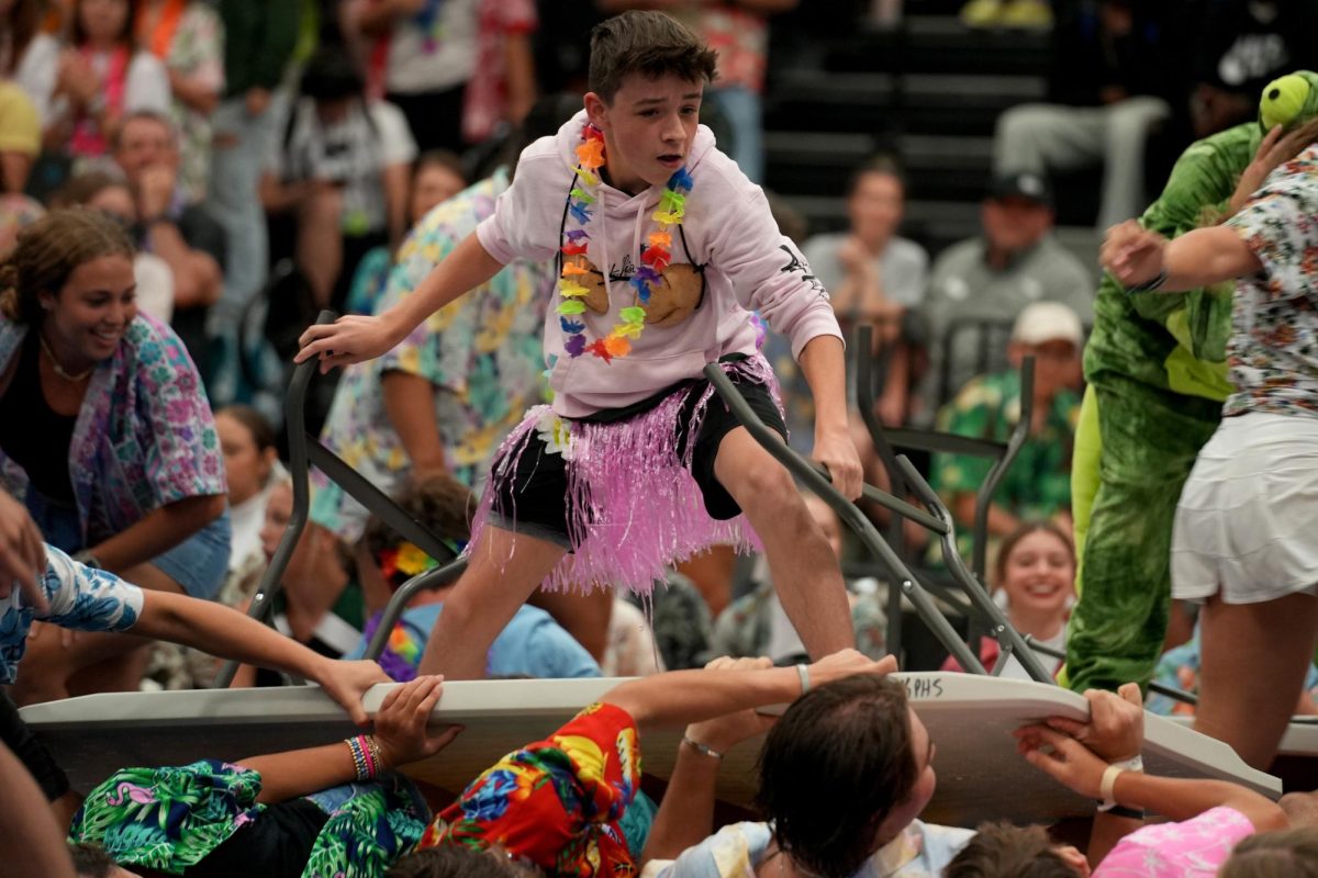 Junior Simon Perry table surfs during the pep rally in August. The juniors won the competition. 