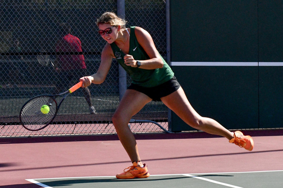 Sophomore Izzy Sikora reaches for the ball at the back of the court in her doubles match against Porter on Sept. 27. Sikora won the decisive match in the first round of the playoffs to help lift the Panthers to the Area Round.