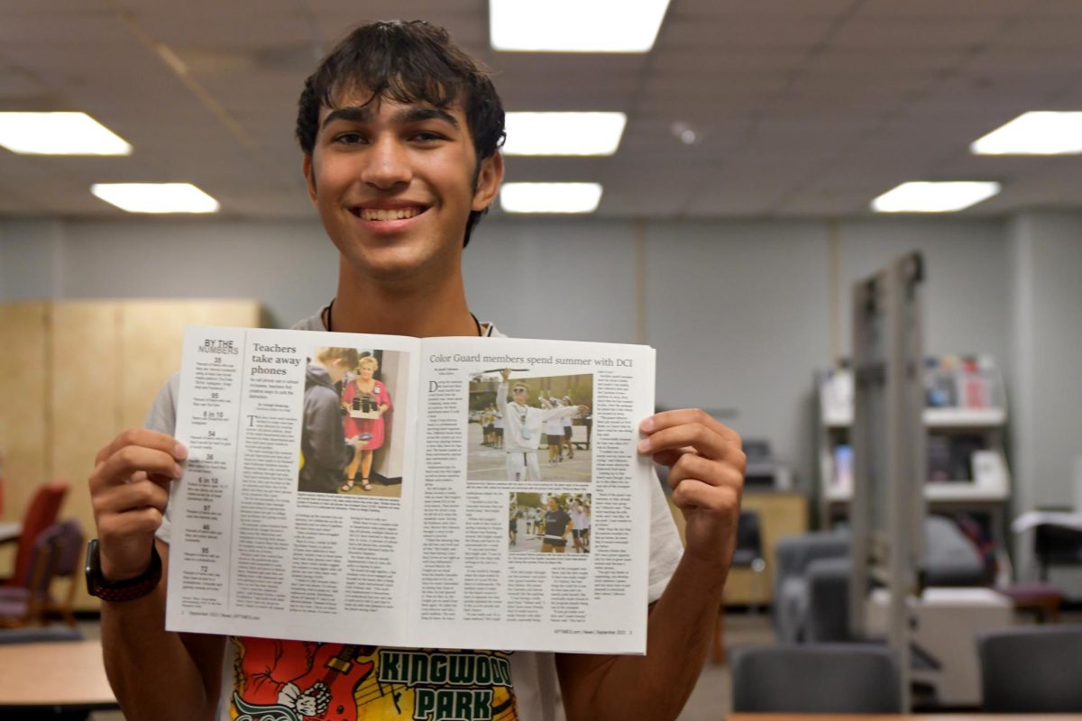 Senior+Jacob+Valcarce+holds+up+the+first+newspaper+issue+of+the+school+year+with+his+story+in+it+on+the+schools+color+guard.+He+has+decided+to+pursue+journalism+in+the+future.