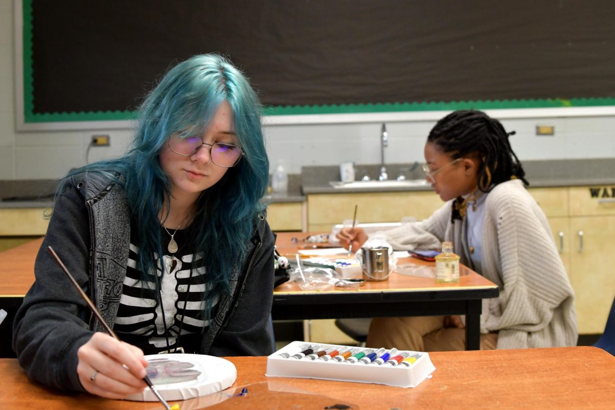Senior Ayla Lydick works with paint in sixth period AP Art as junior Sydnei Sisney works at a nearby table. 