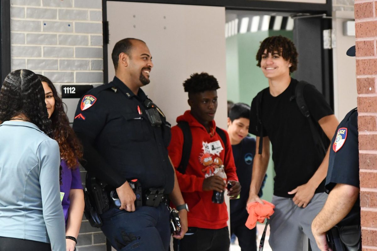 Officer Zachary Daniels talks to students over the lunch hour earlier this month. Students often gravitate toward him to talk. 