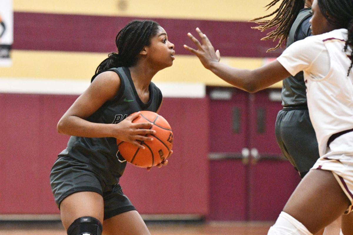 Junior Aniah Cross looks for a pass before throwing it to freshman Rionna Martin. Cross led the team with 23 points in the 61-43 loss to Magnolia West.